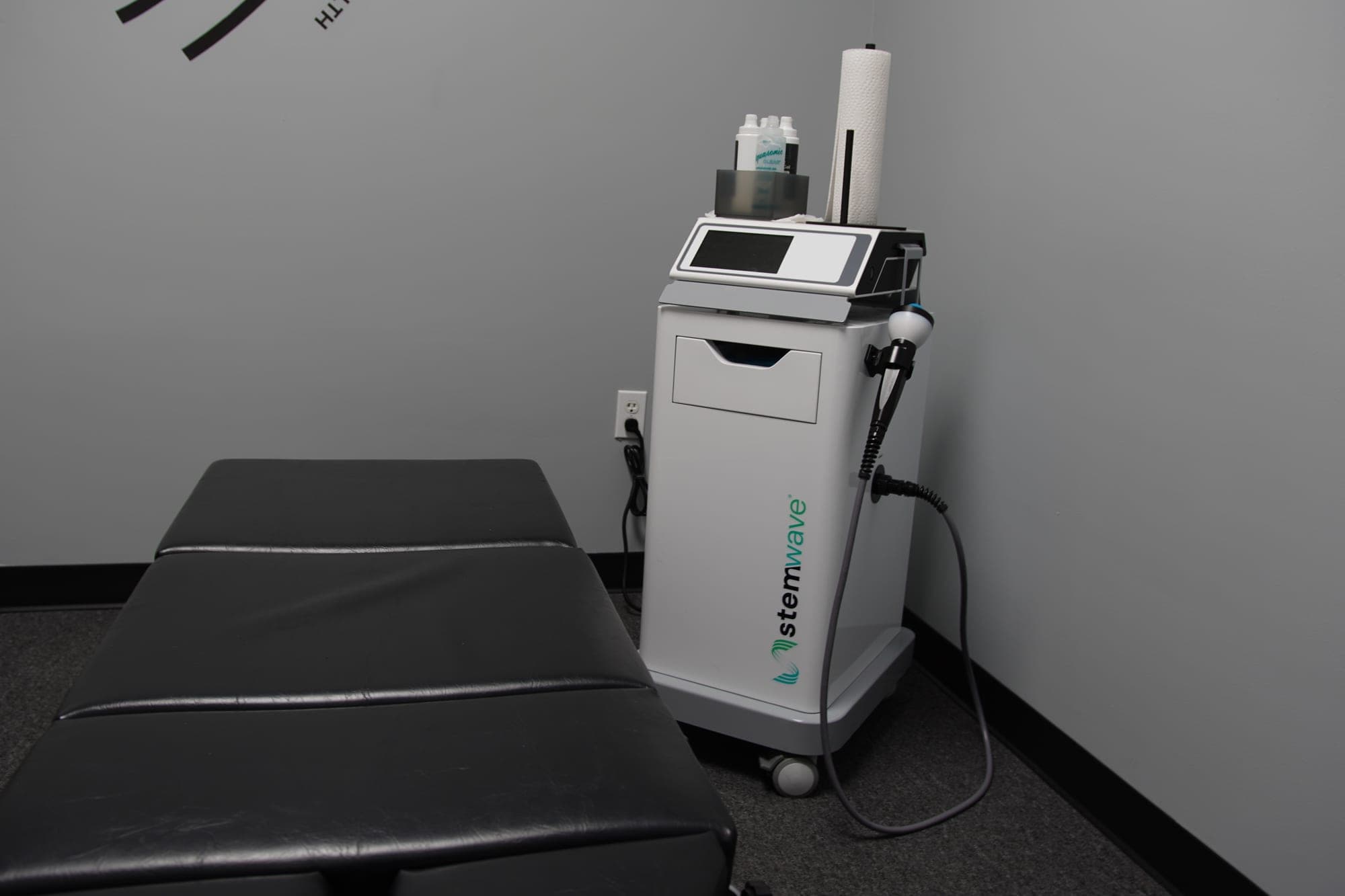 StemWave acoustic wave therapy device in a treatment room at Breakaway Chiropractic & Wellness