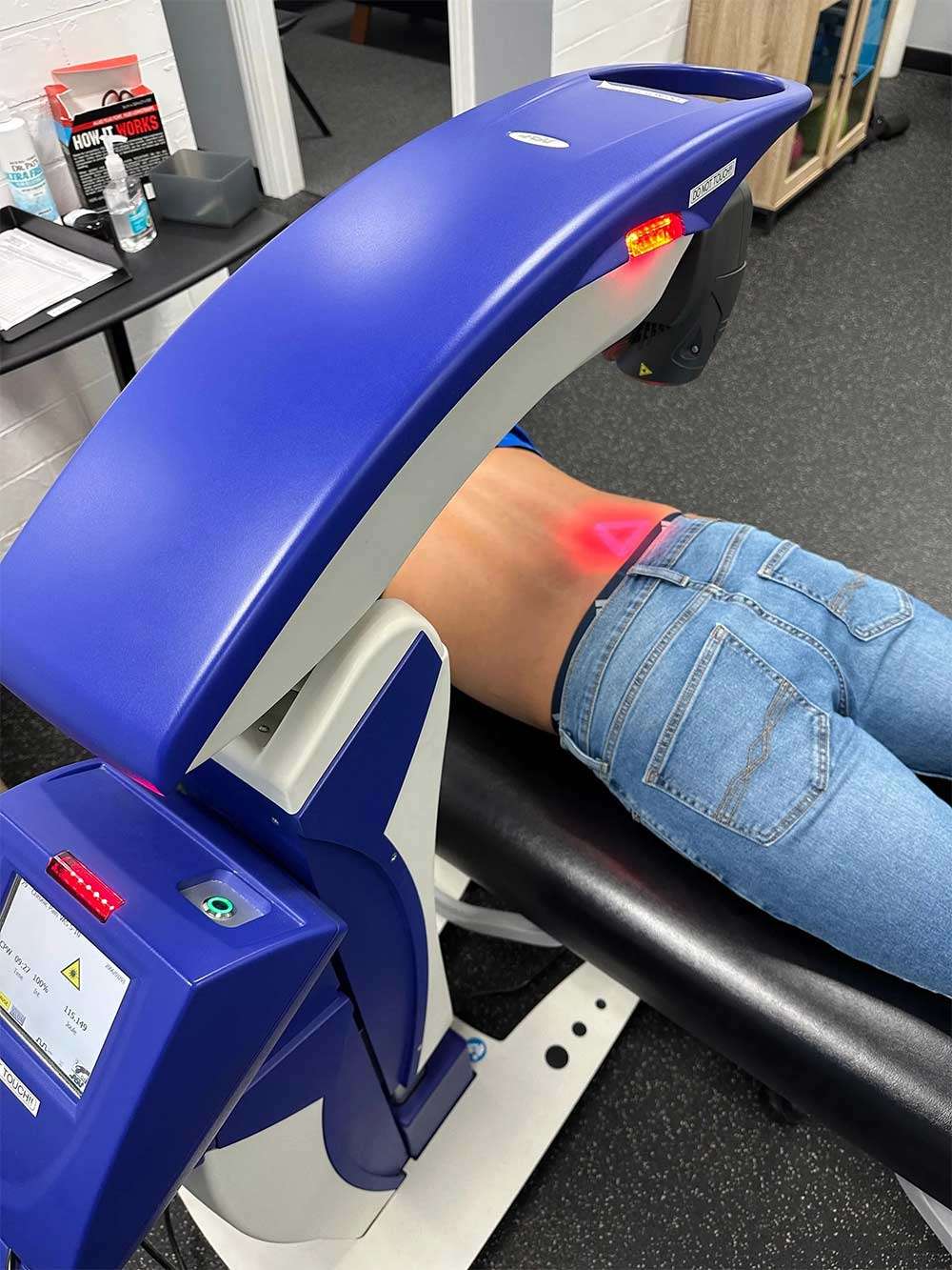 MLS cold laser unit treating a patient's lower back at Breakaway Chiropractic in Frisco, TX