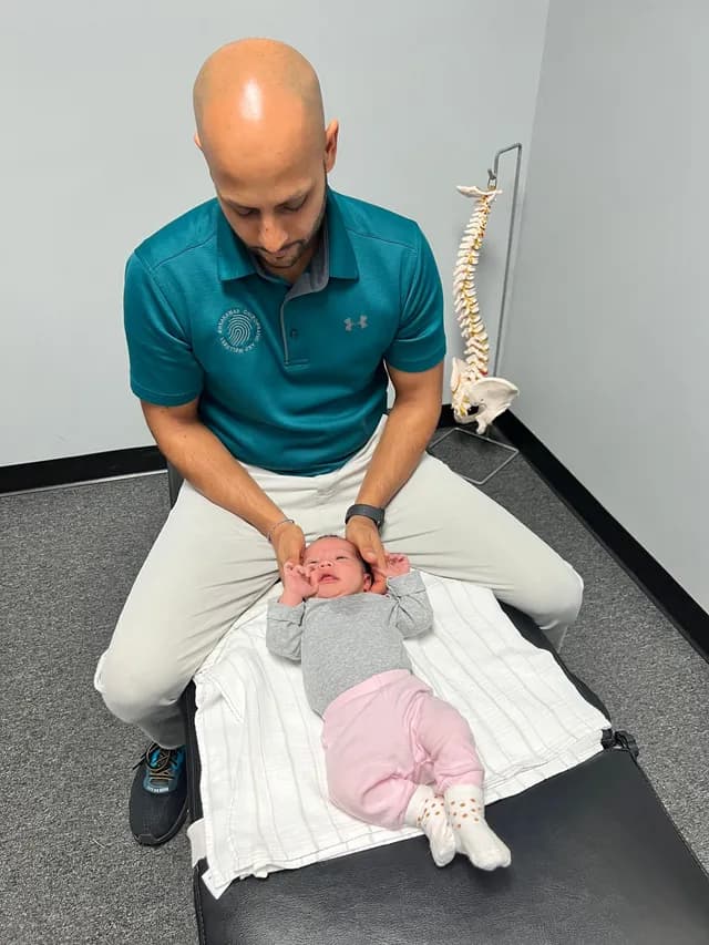 Chiropractor using gentle fingertip pressure on an infant at Breakaway Chiropractic in Frisco, TX